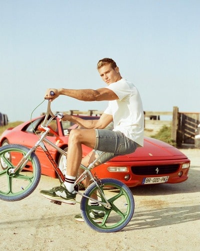 Matthew Noszka riding a bicycle and his Ferrari F355 GTS 